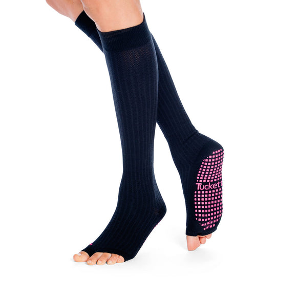 Knee high toe free grip socks in solid black color with pink grips on the bottom